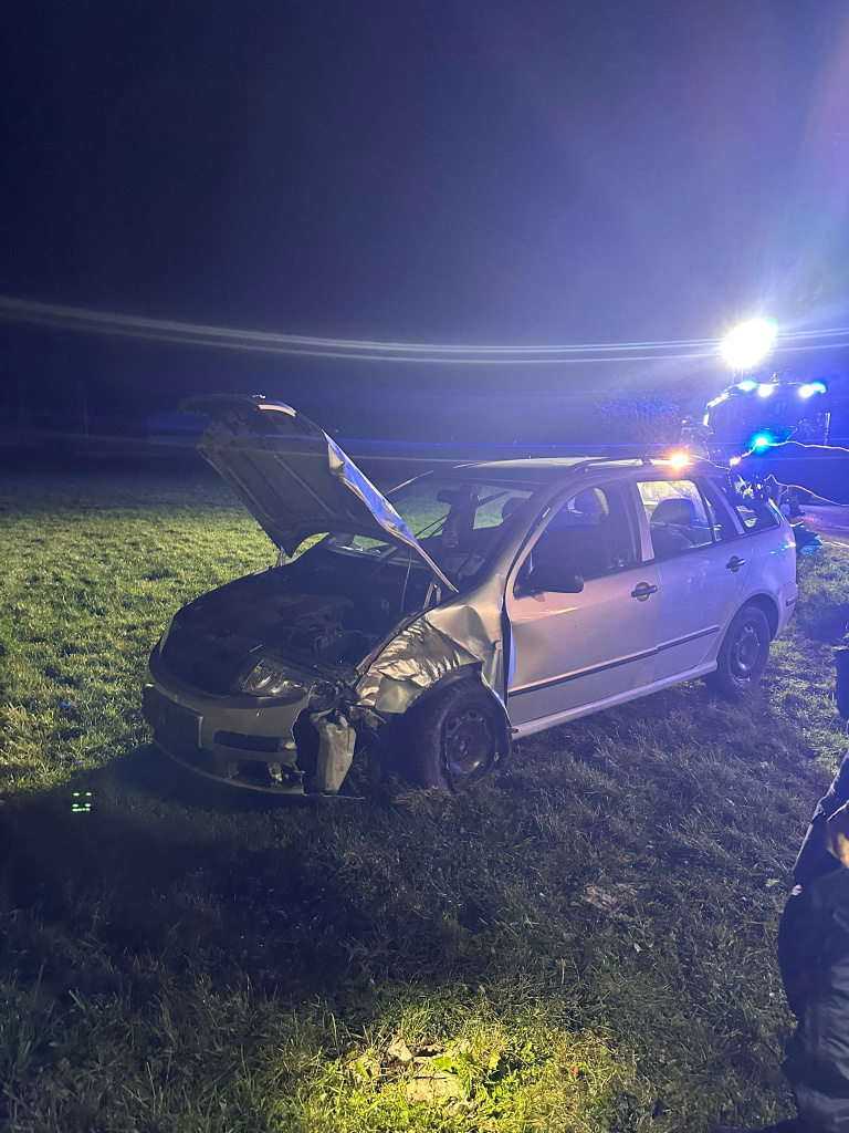 beschädigtes Auto nach Unfall bei Nacht auf Wiese