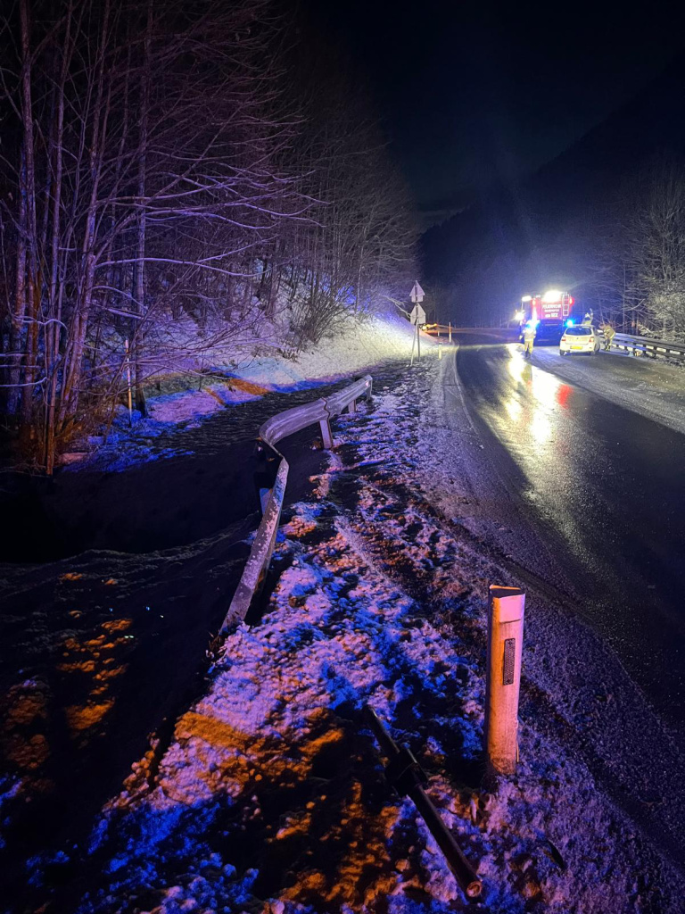 Nächtlicher Feuerwehreinsatz auf winterlicher Straße mit beschädigter Leitplanke und Einsatzfahrzeugen