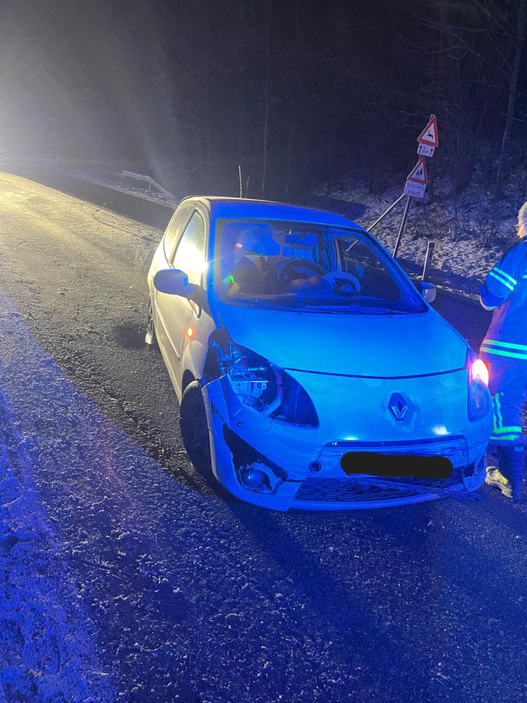 Beschädigter Pkw nach Verkehrsunfall auf winterlicher Straße, Einsatz der Feuerwehr bei Nacht